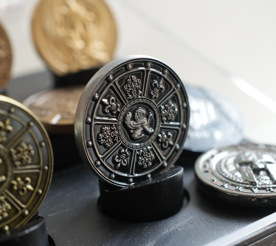 Decorative coins with intricate designs on a reflective surface