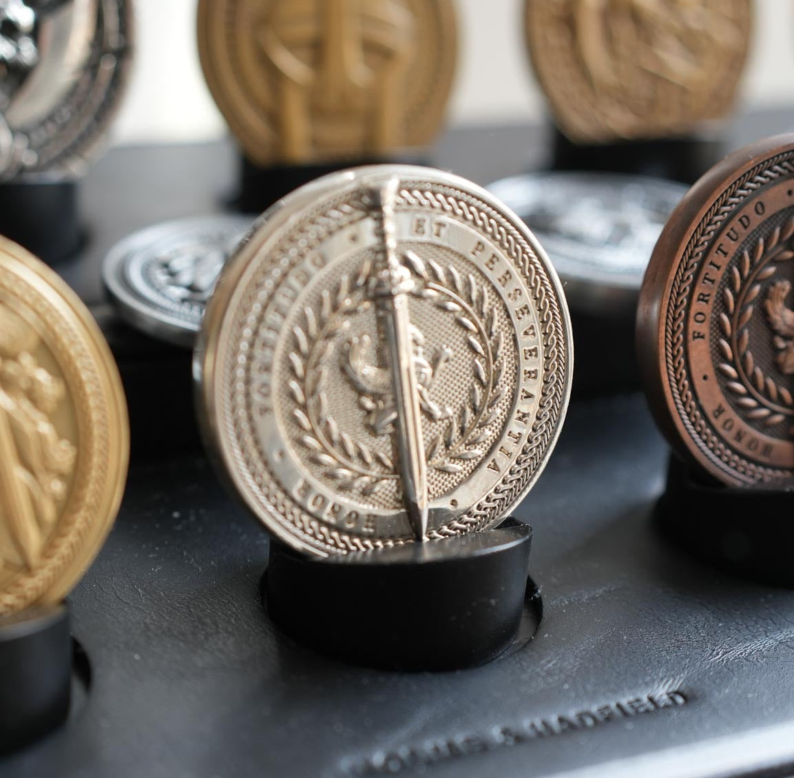 Collection of gold and silver coins on a black stand with blurred background