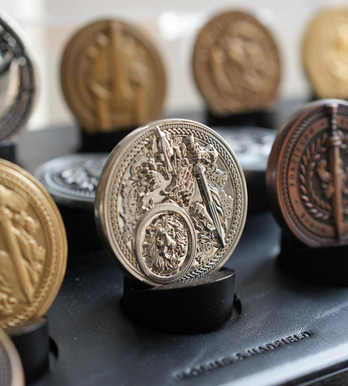 Decorative coins on a black stand with a blurred background