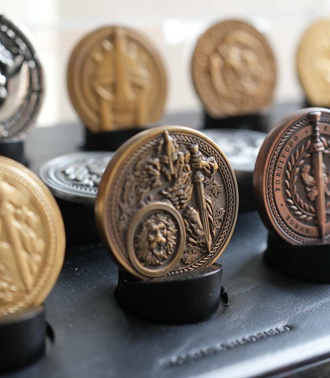 Collection of decorative metal medallions on a black surface with a blurred background