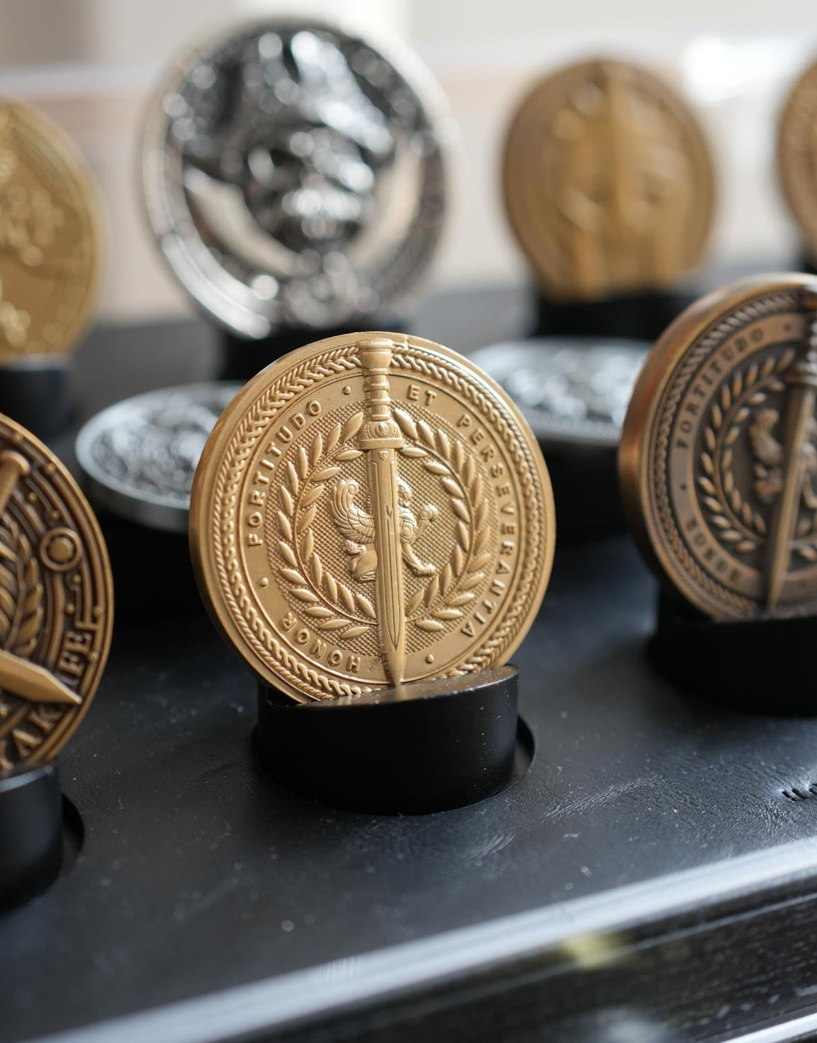 Decorative coins with intricate designs on a black stand.
