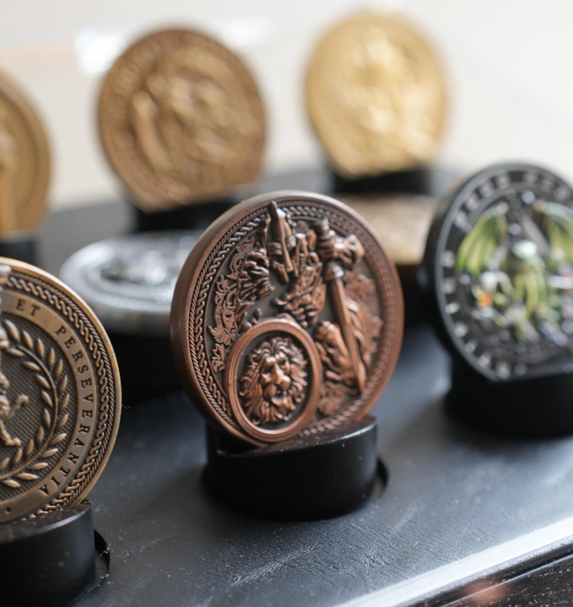 Decorative metal medallions on a black stand with a blurred background
