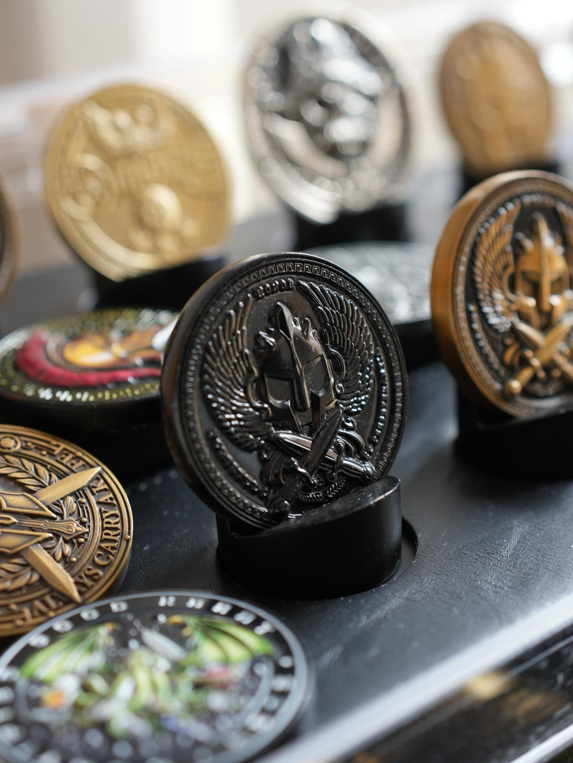Collection of various coins or medallions on a reflective surface