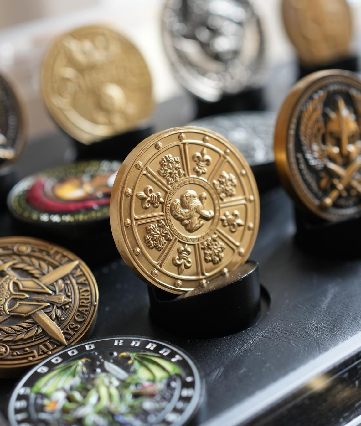 Collection of various coins on a reflective surface with a blurred background
