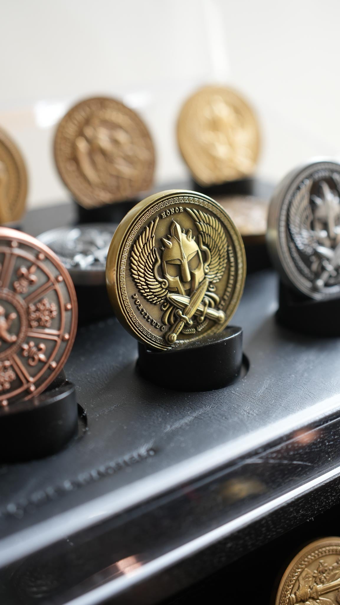 Collection of decorative buttons with intricate designs on a reflective surface.