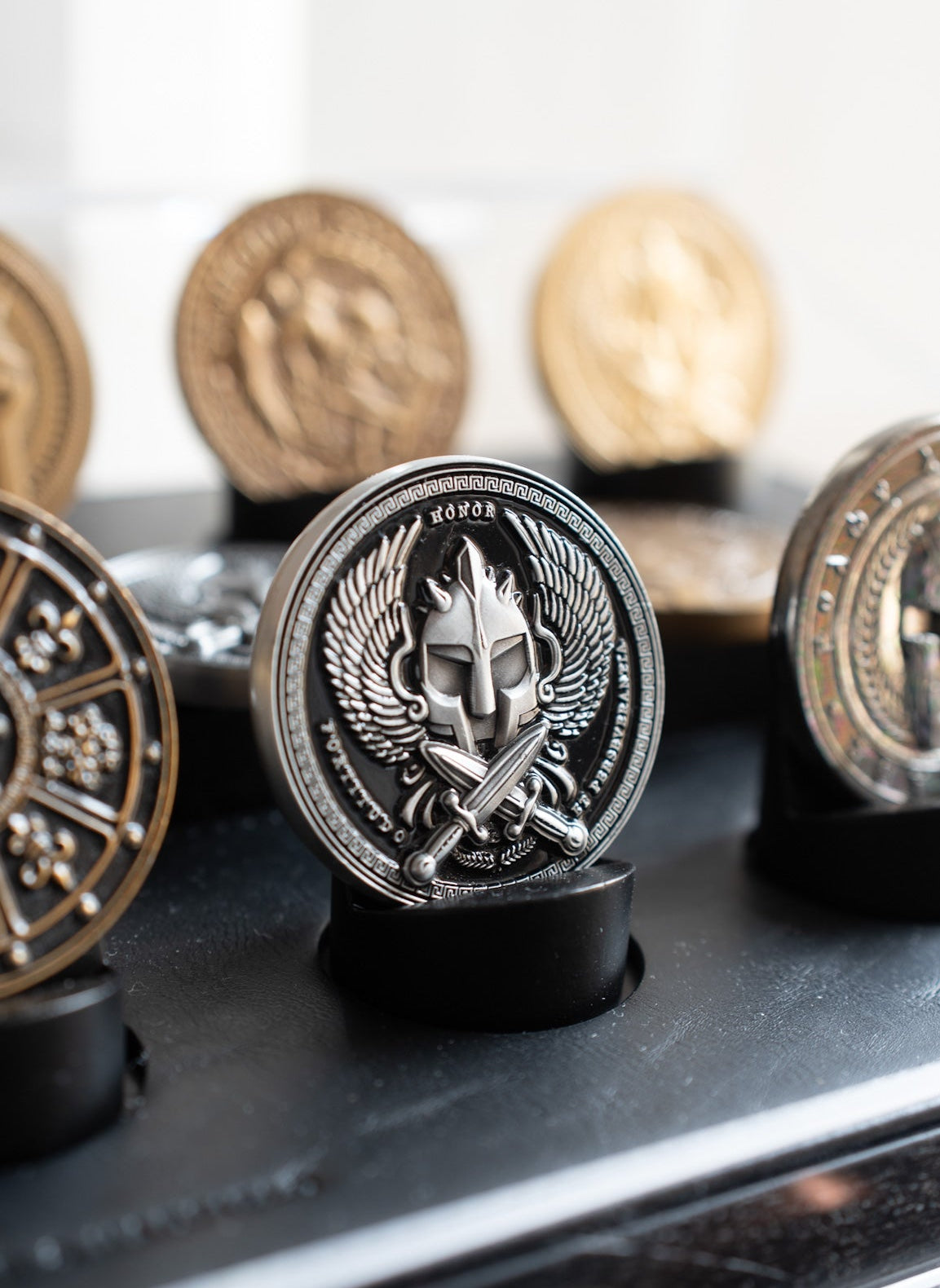 Collection of decorative coins on a reflective surface with a blurred background
