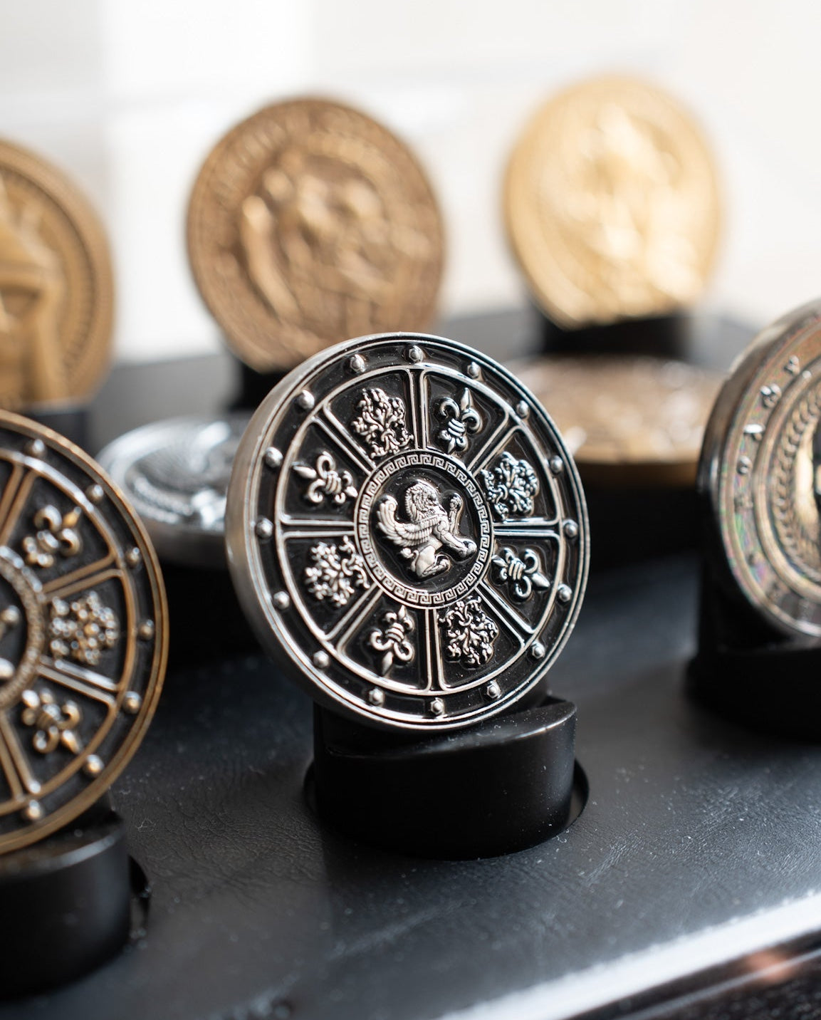 Decorative coins with intricate designs on a reflective surface