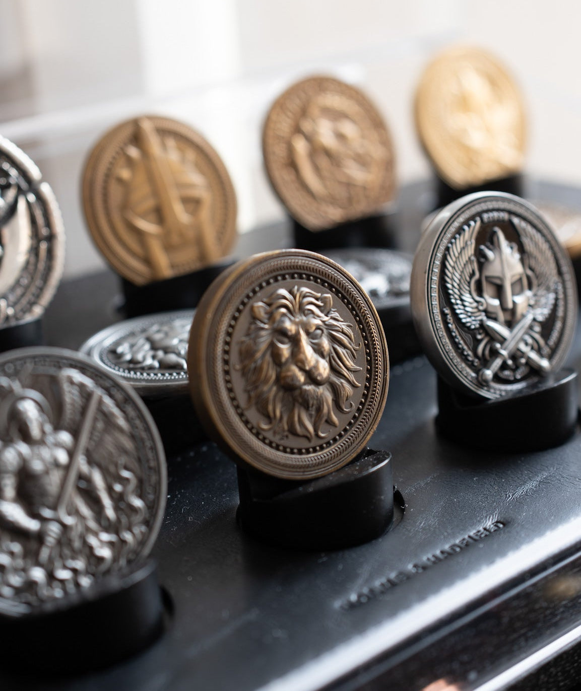Collection of decorative metal buttons with intricate designs on a black surface.